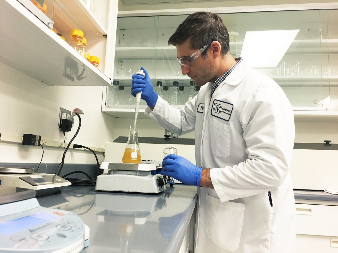 Natren laboratory technician working with a pipette and flask