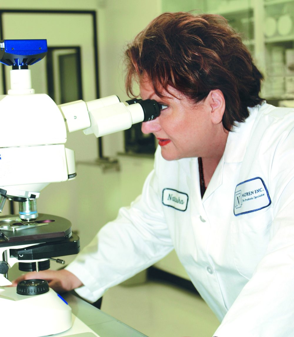 Natasha Trenev frente a un microscopio en el laboratorio de Natren